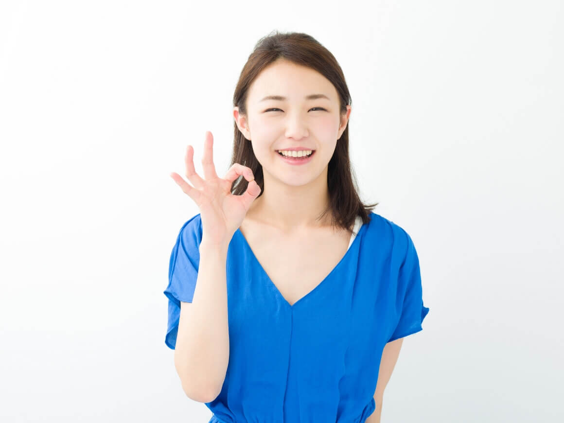 女性が笑ってOKマークをしている写真
