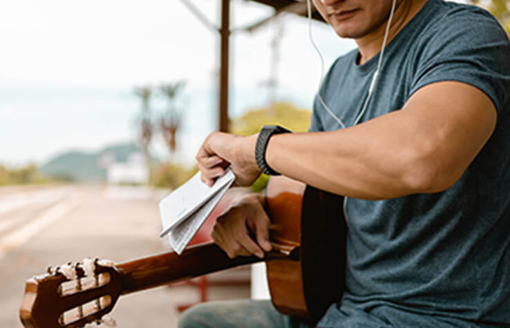 時間を気にするギターを持った男性